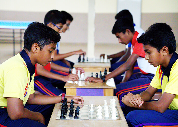 Students playing chess to enhance strategic thinking and focus at NewAge World School