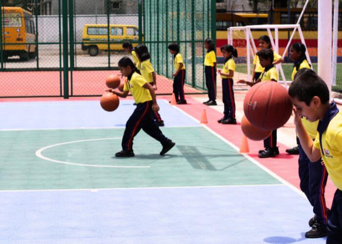 Students practicing basketball skills in the outdoor court