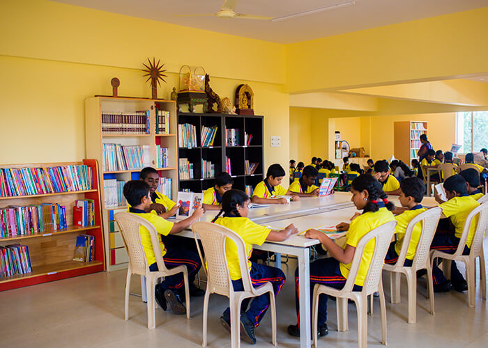 Students reading books in the well-equipped library at NewAge World School