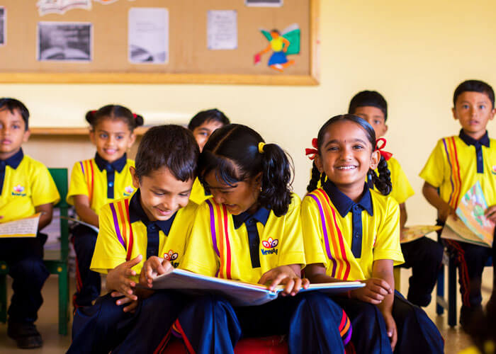 Students reading and enjoying a group activity in the classroom at NewAge World School.