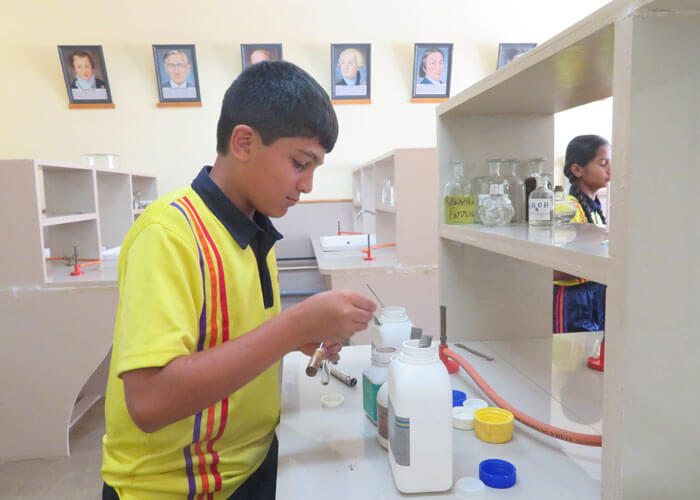 Student conducting a science experiment in the laboratory at NewAge World School.